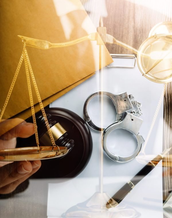 Business and lawyers discussing contract papers with brass scale on desk in office. Law, legal services, advice, justice and law concept picture with film grain effect